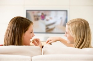 Two women in living room watching television 