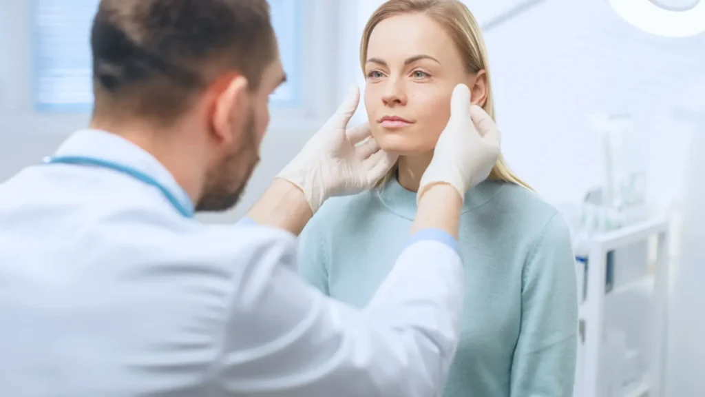 Doctor examining patient’s face during cosmetic surgery consultation